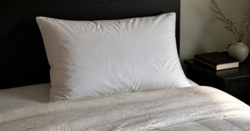 Aufgeschütteltes Daunenkissen auf dem Bett