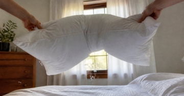 Federkissen mit Kissenbezug auf dem Bett