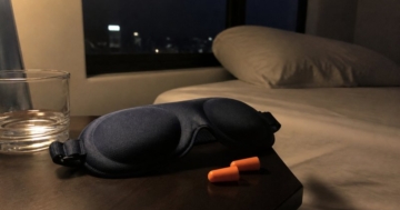 Schlafmaske und Ohrstöpsel auf dem Nachttisch